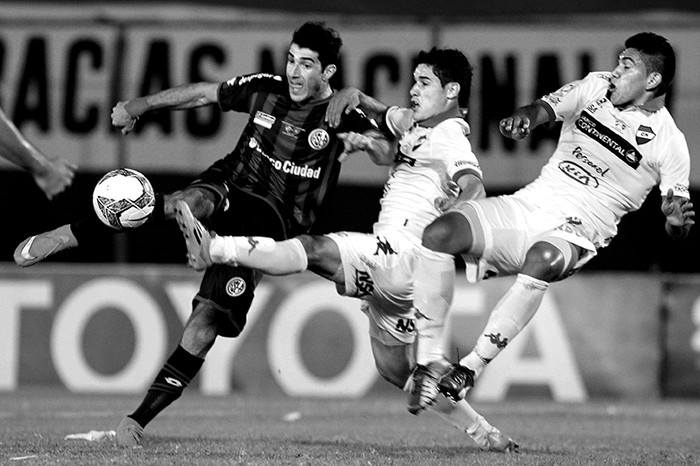 Mauro Matos, de San Lorenzo, ante la marca de Silvio Torales y Raúl Píris, de Nacional, ayer en el estadio Defensores del Chaco de Asunción (Paraguay). / Foto: Andrés Cristaldo, Efe