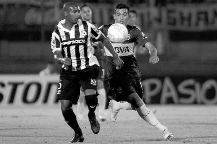 Santiago Martínez, de Wanderers, y Franco Cristaldo, de Boca Juniors, ayer, en el estadio Centenario.  Foto: Hugo Ortuño, efe