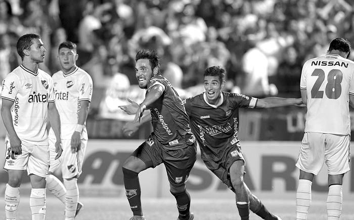 Matías Zunino y Martín Rabuñal, de Defensor Sporting, festejan el tercer gol a Nacional, anoche en el estadio Luis Franzini. Foto: Sandro Pereyra