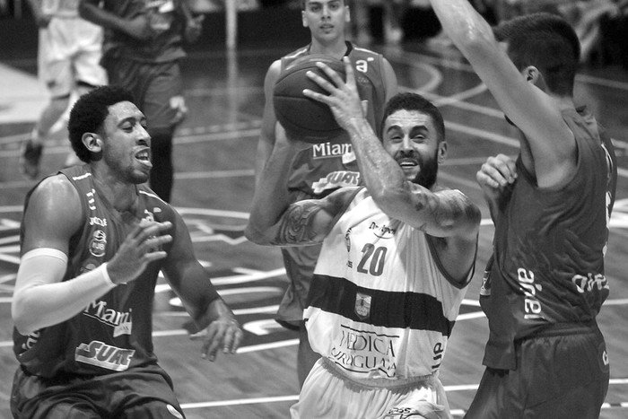 Javier Mojica de Defensor Sporting (c), entre Richard Chaney (i) y Nicolás Borsellino de Biguá, ayer, en la cancha de Bohemios. Foto: Federico Gutiérrez