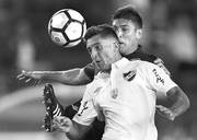 Kevin Ramirez de Nacional y Diego Braghieri de Lanús, ayer, en el estadio Lanús, en Buenos Aires. Foto: Juan Mabromata, AFP