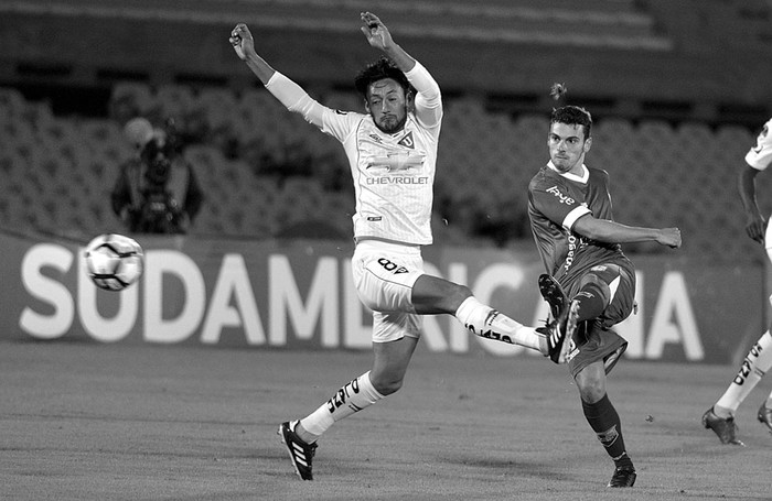 Gonzalo Bueno de Defensor Sporting (d) y Fernando Hidalgo de Liga de Quito, anoche, en el estadio Centenario. Foto: Andrés Cuenca