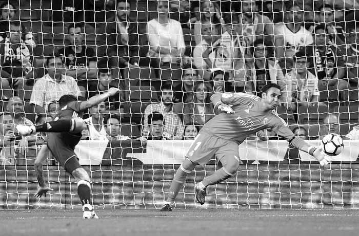 Arnaldo Sanabria (i), de Real Betis, vence al arquero Keylor Navas, de Real Madrid, ayer, en el estadio Santiago Bernabéu de Madrid. Foto: Gabriel Bouys, AFP