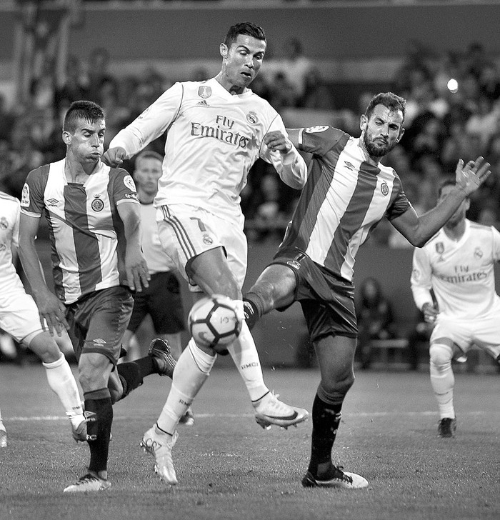 Pere Pons (i) y Cristhian Stuani (d), de Girona, y Cristiano Ronaldo, de Real Madrid, ayer, en el estadio Montilivi de Girona, España. Foto: Josep Lago, AFP