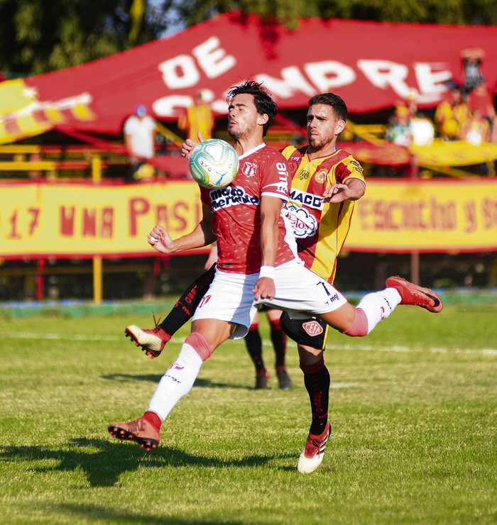 Nicolás Rodríguez, de River Plate, y Danilo Asconeguy, de Progreso, en el estadio Abraham Paladino.  · Foto: Andrés Cuenca