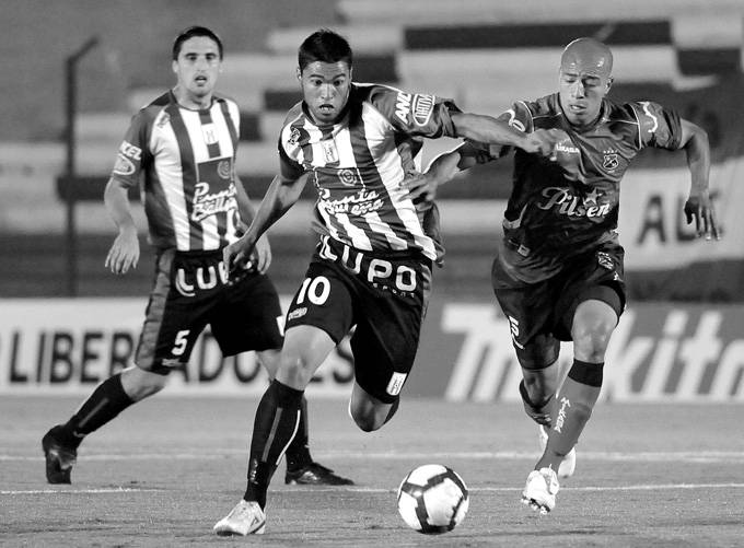 Matias Mirabajes, de Racing; Juan Ortiz, de Deportivo Independiente Medellín; y Santiago Ostolaza, durante el partido jugado en el Parque Central. (archivo, marzo de 2010) · Foto: Pablo Nogueira