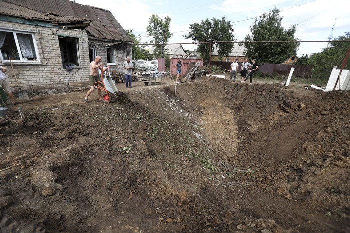 Residentes de Kostyantynivka rellenan un cráter después de un ataque ruso en esta ciudad de Donetsk. · Foto: Anatolii Stepanov, AFP