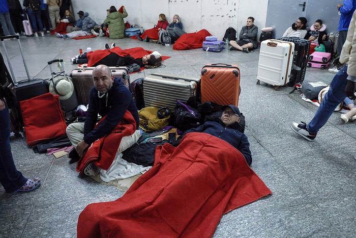 Viajeros con mantas de la Cruz Roja pasan la noche en la estación de tren de Atocha en Madrid, tras el apagón masivo del 28 de abril. · Foto: Óscar del Pozo, AFP