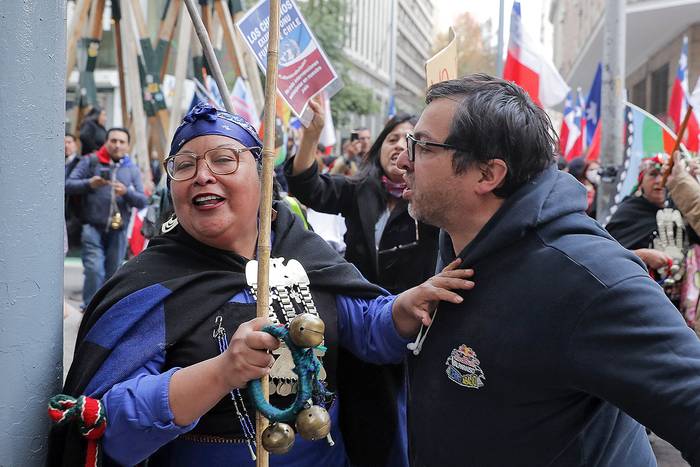 Una mujer mapuche y un manifestante de la derecha chilena que se opone a la redacción de una nueva constitución, afuera del antiguo Congreso Nacional en Santiago, el 7 de junio. · Foto: Javier Torres, AFP