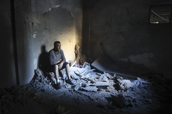 Un hombre palestino dentro de un edificio destruido en el refugio de Nuseirat, en el centro de la Franja de Gaza. · Foto: Eyad Baba, AFP