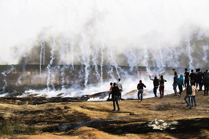 Manifestantes palestinos frente a los gases disparados por el Ejército israelí en la frontera, al este de la ciudad de Gaza. Foto: Mohammed Abed, AFP
 · Foto: Mohammed Abed