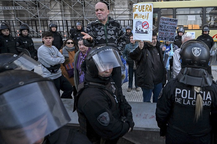 Simpatizantes de la ex presidenta argentina Cristina Fernández y policías frente al Palacio de Tribunales, sede de la Corte Suprema, en Buenos Aires, el 12 de junio. · Foto: Luis Robayo, AFP