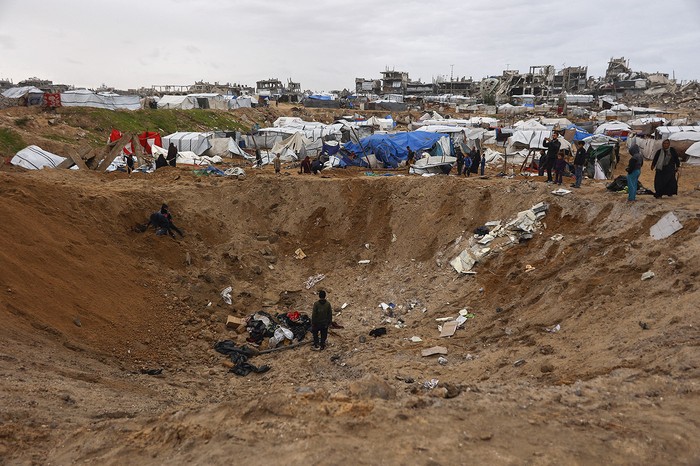 Palestinos el día después de un ataque del ejército israelí, en el campo de refugiados de Al-Shati, en la ciudad de Gaza. · Foto: Omar Al-Qattaa, AFP