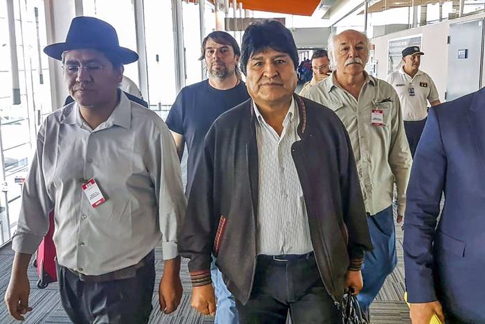 Evo Morales (C), ex presidente boliviano, y Diego Pary Rodríguez, ex canciller boliviano, ayer, en el aeropuerto de Ezeiza en Buenos Aires.
Foto: AFP, ATE Y CTA
