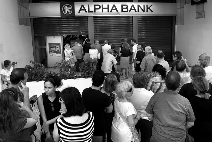 Varias personas hacen cola para retirar dinero de un cajero automático de Grecia Alpha Bank, ayer, en Atenas, Grecia. Foto: Alexandros Vlachos, efe