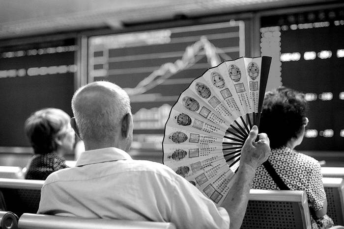 Inversores miran pantallas que muestran los movimientos del mercado de valores, ayer, en Pekín, China. Foto: Fred Dufour, Afp