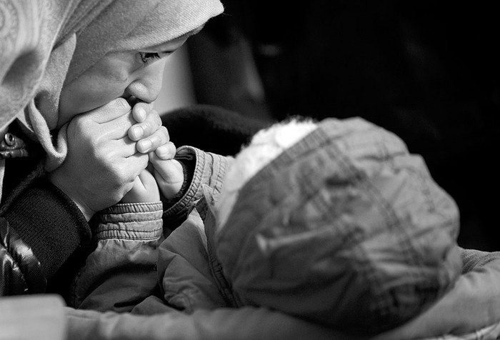 Una madre migrante calienta las manos de su hijo mientras esperan para registrarse en la Oficina de Estado de Sanidad y Asuntos Sociales, ayer, en el centro de Berlín, Alemania. Foto: Kay Nietfeld, Afp