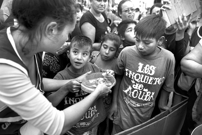 Activistas sirven comida, durante una protesta de organizaciones sociales que bloquean el puente Pueyrredon, en Buenos Aires. Foto: Eitan Abramovich, AFP
