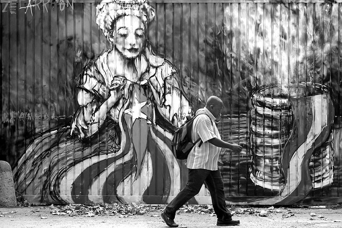 Mural del artista callejero Zecarrion, que representa a una mujer cosiendo una bandera catalana pro-indepencia, junto a la bandera española, ayer, en Barcelona. Foto: Pau Barrena, AFP