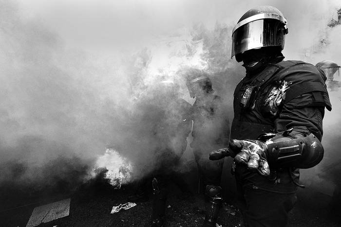 Policía antidisturbios después de que cayera una bomba de humo, durante enfrentamientos entre manifestantes y policías, ayer, en Barcelona. Foto: Lluis Gene, AFP
