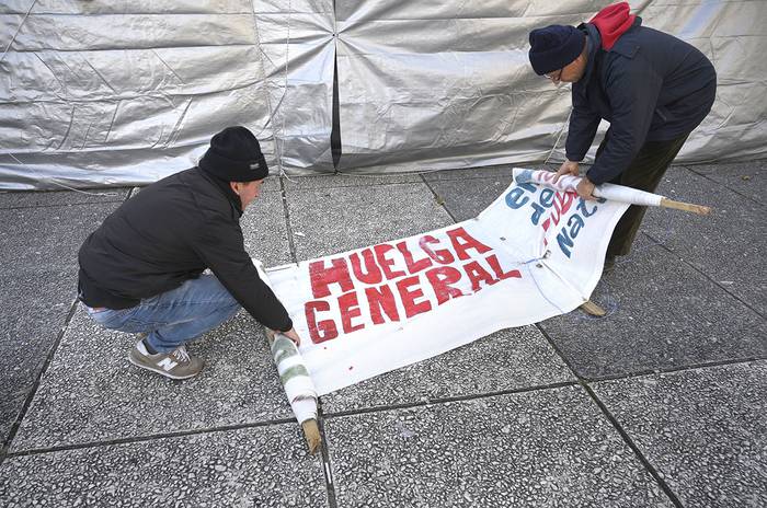 Sindicalistas de Montevideo Gas, desmantelan, ayer, el campamento en la Plaza Independencia. · Foto: Eitan Abramovich, AFP