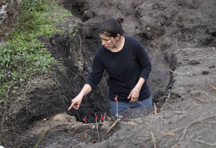 Una integrante de equipo de antropólogos, junto a los restos humanos hallados en el Batallón 13. · Foto: Mariana Greif