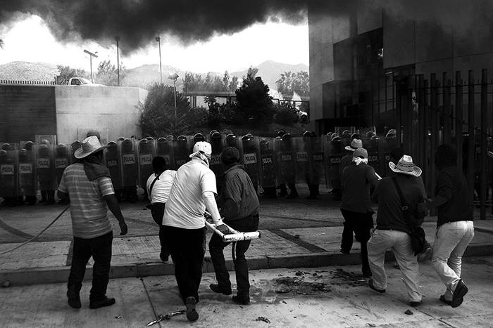 Profesores, estudiantes y familiares de los 43 jóvenes que desaparecieron hace 17 días  frente a la policía en la sede del gobierno y del Congreso de Guerrero, en el sur de México./ Foto: Lenin Ocampo, Efe