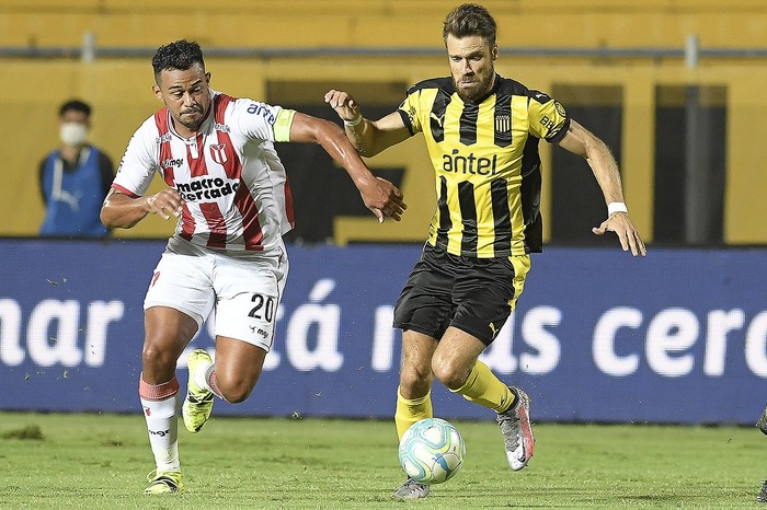 Sebastián Píriz, de River Plate, y Gary Kagelmacher, de Peñarol, durante el partido por la fecha 11 del Torneo Clausura, el 6 de marzo de 2021, en el estadio Campeón del Siglo. · Foto: Sandro Pereyra