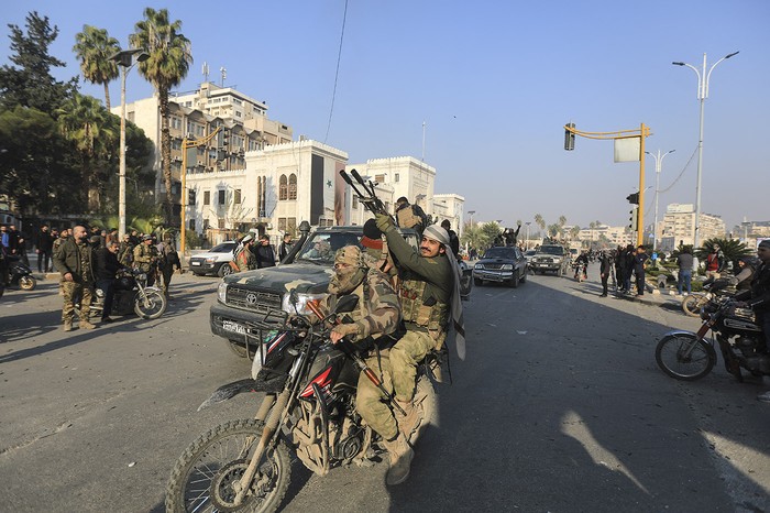 Combatientes antigubernamentales desfilan en las calles de Hama después de que las fuerzas capturaron la ciudad del centro de Siria. · Foto: Bakr Al kasem, AFP