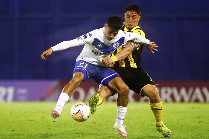 Pablo Galdames, de Vélez Sarsfield, y Cristian Rodríguez, de Peñarol, en el estadio José Amalfitani, en Buenos Aires.  · Foto: Marcos Brindicci, pool, AFP