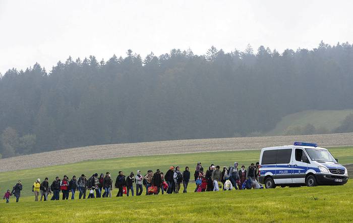 Inmigrantes marchan desde la frontera entre Austria y Alemania hasta un primer punto de registro de la Policía Federal alemana en la pequeña aldea bávara de Wegscheid, en el sur de Alemania.
 · Foto: Christof Stache
