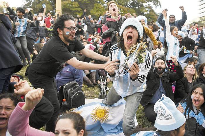 Hinchas argentinos festejan cuando Marcos Rojo anotó el segundo gol a Nigeria, ayer, en una pantalla en la plaza San Martín de Buenos Aires. · Foto: Eitan Abramovich