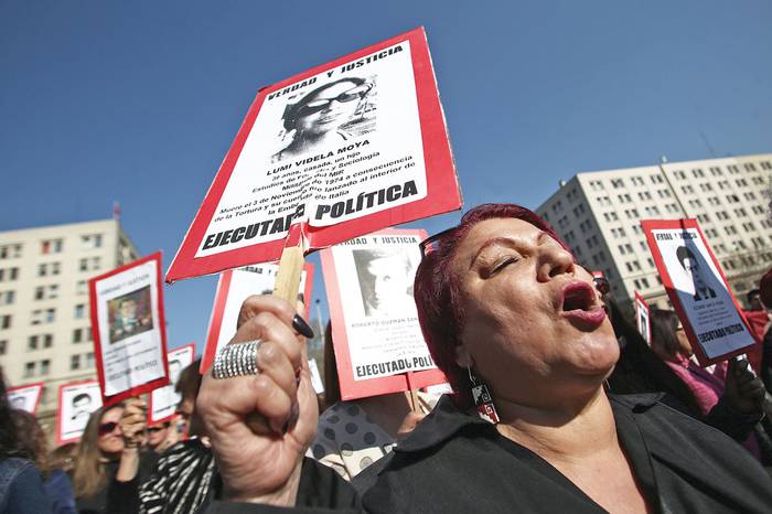 Activistas chilenos de derechos humanos durante una manifestación conmemorativa del 45º aniversario del golpe militar encabezado por el general Augusto Pinochet, ayer, en Santiago.
 · Foto: Claudio Reyes