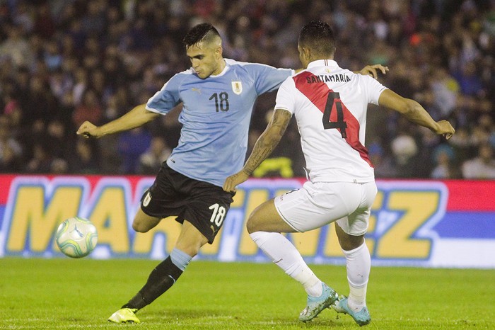 Maximiliano Gómez , de Uruguay, y Anderson Santamaría , de Perú, el viernes, en el estadio Centenario.  · Foto: .