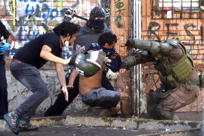 Manifestantes se enfrentan con la policía antidisturbios, durante una protesta contra el gobierno, el sábado, en Santiago. · Foto: Claudio Reyes, AFP