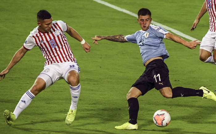 Jorge Morel, de Paraguay, y Juan Ignacio Ramírez, de Uruguay durante el Torneo Preolímpico Sudamericano Sub-23 en el estadio Centenario en Armenia, Colombia. · Foto: Juan Barreto, AFP