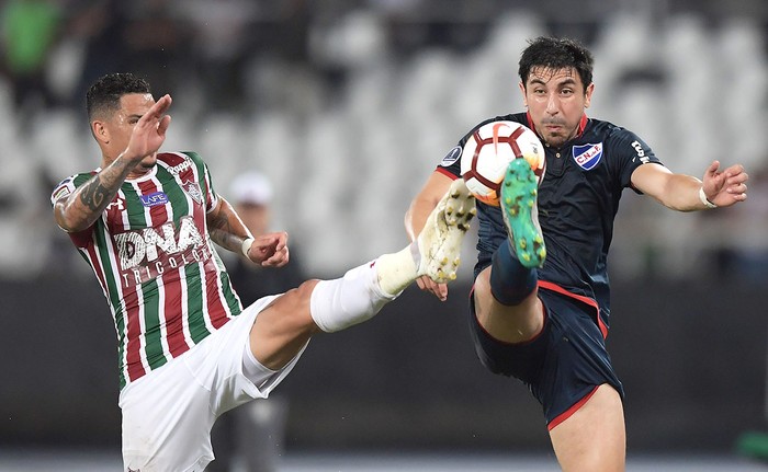 Luciano, de Fluminense, y Jorge Fucile, de Nacional, el 24 de octubre, en el estadio Milton Santos, Río de Janeiro. · Foto:  Carl De Souza