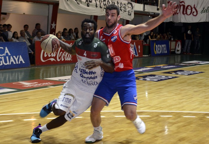 Dwayne Davis, de Aguada, y Santiago Moglia, de Nacional, el 18 de enero, en la cancha de Aguada. · Foto: Santiago Mazzarovich