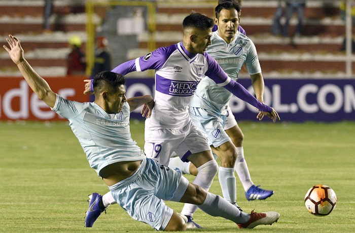 Leonel Justiniano, de Bolívar (i) y Pablo López, del Defensor Sporting, en el Estadio Hernando Siles, en La Paz, Bolivia, el 23 de enero. · Foto: Aizar Raldes