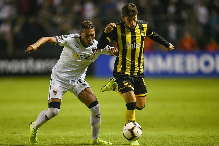 Agustín Canobbio, de Peñarol, y José Quintero, la Liga de Quito, en el estadio Casa Blanca de Quito.

 · Foto: Rodrigo Buendía, AFP