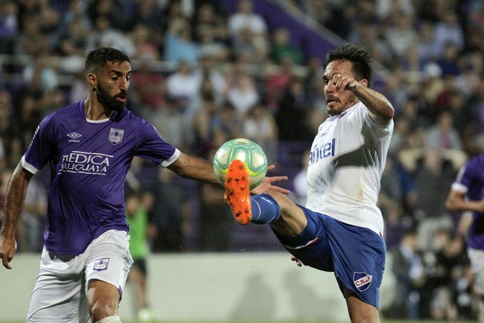 Hernán Menosse, de Defensor Sporting, y Matias Zunino, de Nacional, ayer, en el estadio Luis Franzini. · Foto: .