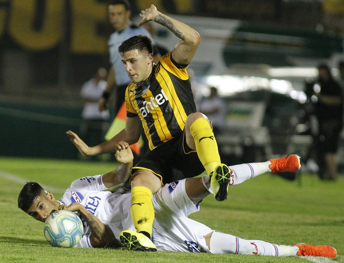 Giovanni González, de Peñarol, y Santiago Rodríguez, de Nacional, el miércoles, en el estadio Centenario. · Foto: .