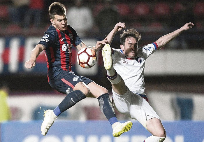 Nicolas Reniero, de San Lorenzo, y Matías Zunino, de Nacional, ayer, en el estadio Pedro Bidegain en Buenos Aires. · Foto: Juan Mabromatta