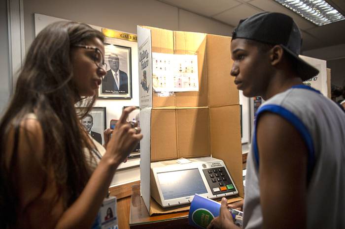 Jóvenes votantes brasileños durante un aprendizaje para usar las boletas electrónicas, en el Tribunal Regional Electoral de Río de Janeiro, Brasil. · Foto: Mauro Pimentel