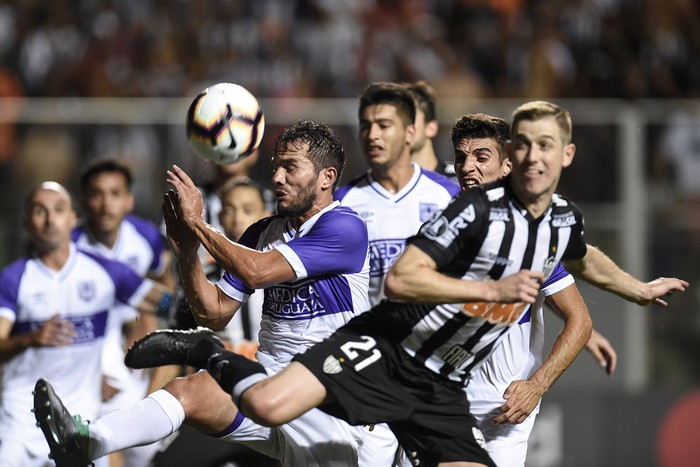 Álvaro González (c), de Defensor Sporting, y Adilson, de Atlético Mineiro, ayer, en Belo Horizonte, Brasil.
 · Foto: Douglas Magno