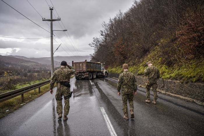 Oficiales alemanes inspeccionan una barricada en la carretera instalada con camiones en la aldea de Rudare, cerca de la ciudad de Zvecan, el 12 de diciembre de 2022. · Foto: Armend Nimani, AFP