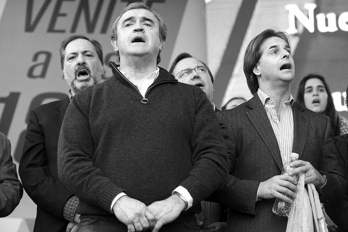Jorge Gandini, Jorge Larrañaga y Luis Lacalle Pou en la celebración del 180º aniversario del Partido Nacional, el sábado, en la plaza Matriz. Foto: Santiago Mazzarovich