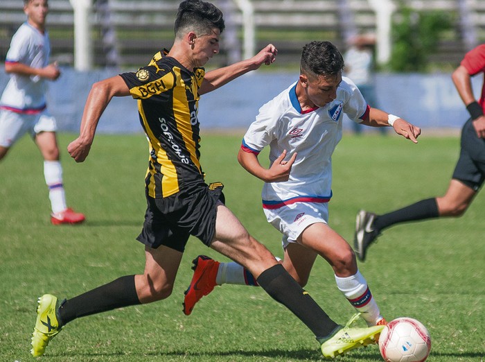 Andrés Madruga, de Peñarol, y Bruno Barboza, de Nacional, en el clásico de séptima, ayer, en el Parque Capurro.
 · Foto: Juan Manuel Ramos