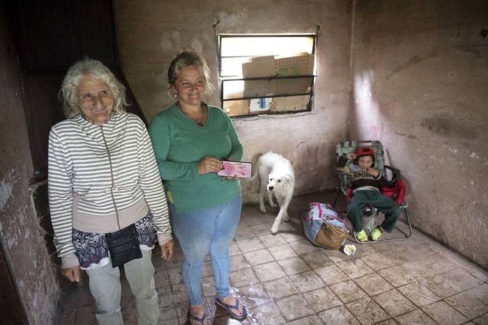Raquel, Jenny y Bautista (abuela, madre y nieto), en su casa del Barrio La Ose, en Durazno. Ayer el nivel del agua llegaba al patio trasero. · Foto: Andrés Cuenca