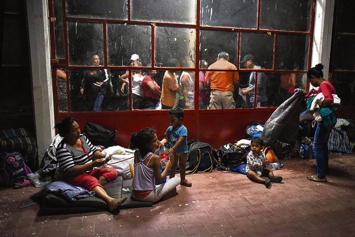 Migrantes centroamericanos que participan en la caravana Viacrucis migrante, descansan, ayer, en un campo deportivo en Matías Romero, estado de Oaxaca, México. 
foto: victoria razo, afp · Foto: Victoria Razo